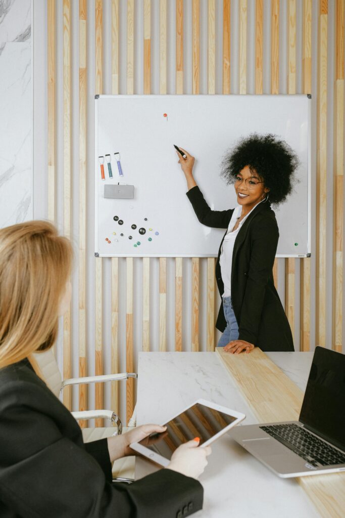 pexels-photo-3727511-3727511 Confident businesswoman leading a presentation using a whiteboard in a modern office.